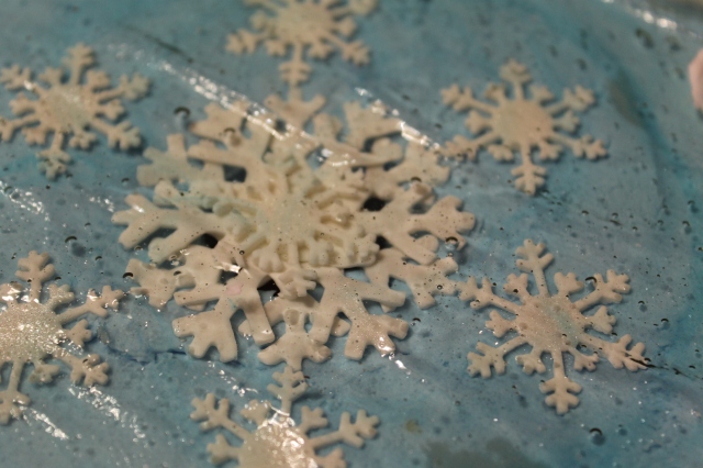 I placed the gumpaste snowflakes onto medium blue buttercream then placed the hard candy ice over it.
